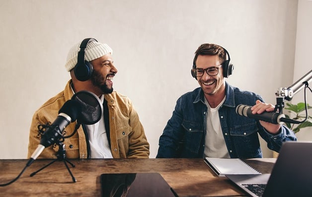 Two men doing a podcast sitting at a desk