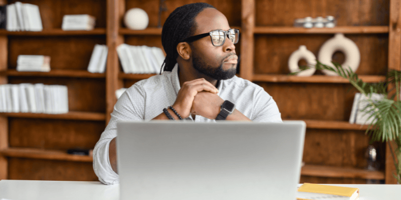 Young professional seated at his desk thinking about HubSpot integrations